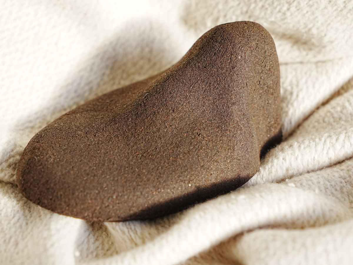 Kahyve shoe tree on a cream linen throw, seen from the side